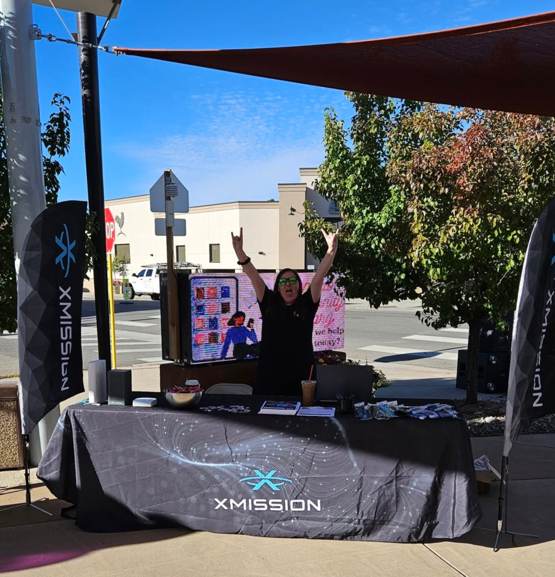 An XMission team member greeting visitors at a community outreach booth in Colorado