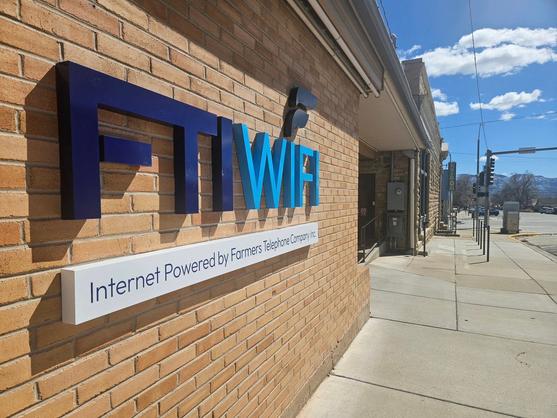 The FTI WIFI office sign on a brick building in downtown Ignacio, Colorado
